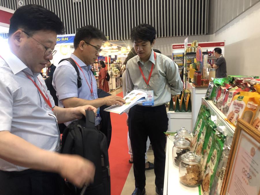Khách nước ngoài tìm hiểu sản phẩm dừa chế biến Việt Nam. Ảnh: PA.